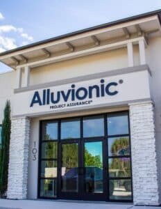 A white building with a sign that says "Alluvionic Project Assurance" on it in blue lettering.