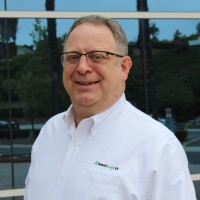 A man smiling in a white shirt in a professional setting