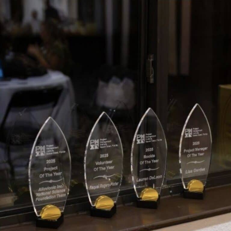 Glass PMI Space Coast Chapter awards lined up, displaying multiple 2025 Project Management Institute honors.